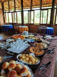 une table remplie de nourriture et de assiettes de nourriture dans l'établissement Pousada Colar de Ouro Chalés, à Cunha