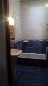 uma casa de banho com uma banheira e um lavatório e uma banheira em Departamento Familiar Amplio y cómodo em Santiago del Estero