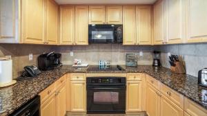 a kitchen with a stove top oven and a microwave at Portofino Island Resort in Pensacola Beach