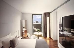 a white bedroom with a bed and a living room at ME London by Melia - Covent Garden in London