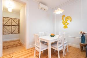 a white dining room with a white table and chairs at Baixa Cozy 2BR with AC - by LU Holidays in Lisbon