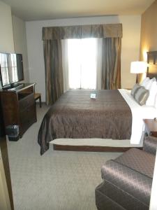 
a hotel room with a large bed and a large window at Teddy's Residential Suites Watford City in Watford City
