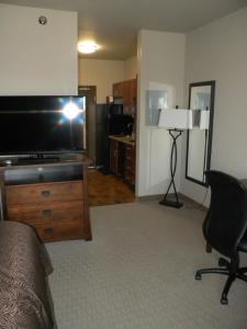 a living room filled with furniture and a tv at Teddy's Residential Suites Watford City in Watford City