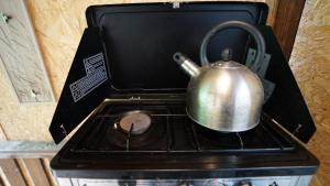 a tea kettle sitting on top of a stove at Showman's Hut Westcote in Hawick