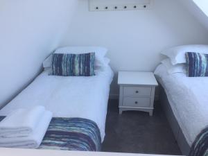 two beds sitting next to each other in a room at Cosy sea view cottage Isle of Skye in Colbost