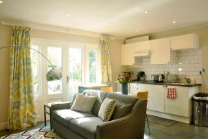 a living room with a couch and a kitchen at Immaculate Quiet Coach House in Garden Birmingham in Birmingham