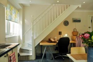een kamer met een bureau en een trap met een tafel bij Immaculate Quiet Coach House in Garden Birmingham in Birmingham