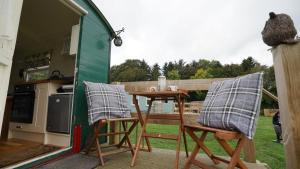 uma mesa e duas cadeiras sentadas num alpendre em Shepherd's Hut Westcote em Hawick