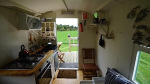 uma cozinha com um lavatório e um fogão forno superior em Shepherd's Hut Westcote em Hawick