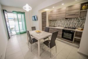 a kitchen with a table and chairs in a room at Home Square in Milazzo