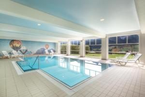 ein großer Pool in einem Haus mit Fenstern in der Unterkunft Luxury Alpine Apartment in Chateau-d'Oex