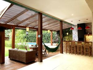 un patio abierto con una hamaca en la terraza en Casa linda c Piscina e WiFi na Praia de Camburi - SP, en São Sebastião