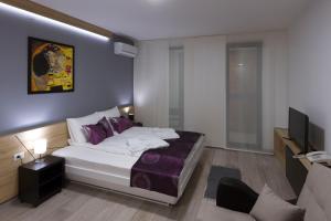 a bedroom with a large bed and a tv at B&B Nataly 2 in Soko Banja
