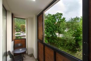 a room with a large window and a table and chair at B&B Nataly 2 in Soko Banja