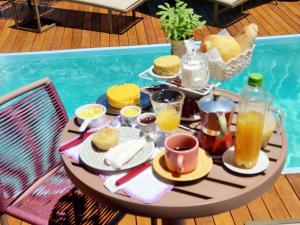 a table with breakfast food and drinks next to a pool at Vila Lua de Taipu - Taipu de Fora in Barra Grande