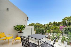 eine Terrasse mit einem Tisch und Stühlen auf dem Balkon in der Unterkunft Giovannina N5 in Cassis