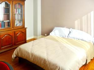 a bedroom with a bed and a wooden cabinet at Maison accueillante à Lanester - Confort et espace pour 6 pers. in Lanester