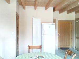 a kitchen with a table and a white refrigerator at Maison accueillante à Plehedel avec jardin et parking privé in Pléhédel +12 photos