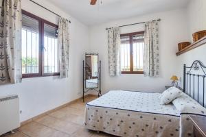a bedroom with a bed in a room with windows at Comfortable House in Carcabuey with Private Pool in Carcabuey