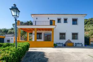 Casa blanca y amarilla con luz de la calle en 5 bedrooms house with private pool and enclosed garden at Carcabuey, en Carcabuey
