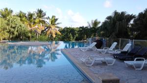 a pool with chaise lounge chairs and a swimming pool at Appartement moderne à Saint-François 90 m² avec piscine partagée in Saint-François