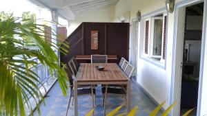 a wooden table and chairs on a balcony at Appartement moderne à Saint-François 90 m² avec piscine partagée in Saint-François
