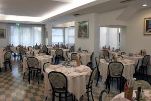 a dining room with tables and chairs in a room at Hotel Rosy in Rimini