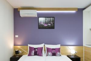 a bedroom with purple walls and a bed with purple pillows at B&B Nataly 2 in Soko Banja