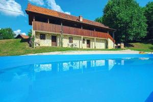 a house with a pool of water in front of it at Elegant villa with jacuzzi near Možđenec in Možđenec