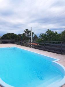 une grande piscine bleue au-dessus d'une clôture dans l'établissement 3 bedrooms villa with private pool and wifi at Caccamo 9 km away from the beach, à Caccamo