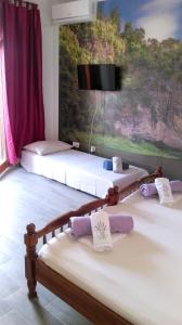 2 Betten in einem Zimmer mit einem TV an der Wand in der Unterkunft Comfortable Studio in Sumartin with Sea View - 22 m² in Sumartin
