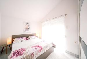 a white bedroom with a bed and a window at Sea View Apartment + Pool, Ljubač, 32 m² in Ljubač +24 photos