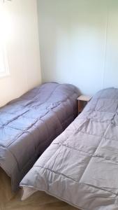 two beds in a room with a bedspread on it at Bungalow charmant à Onzain avec vue sur jardin in Onzain
