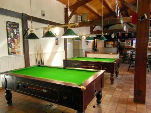 ein Zimmer mit zwei Billardtischen in einem Restaurant in der Unterkunft Bungalow convivial à Saint-Jean-de-Monts avec piscine partagée in Saint-Jean-de-Monts