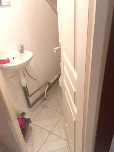 a bathroom with a sink and a toilet and a door at Maison de 2 chambres avec terrasse amenagee et wifi a Pointe Noire a 2 km de la plage in Pointe-Noire