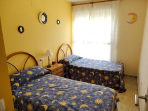 a bedroom with two beds and a window at Comfortable Apartment in Dénia + Pool in Denia +19 photos