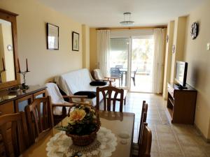 a kitchen and living room with a table and a living room at Comfortable Apartment in Dénia + Pool in Denia