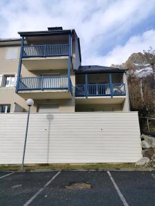 a house with a white fence in a parking lot at Appartement d'une chambre avec balcon a Cauterets in Cauterets