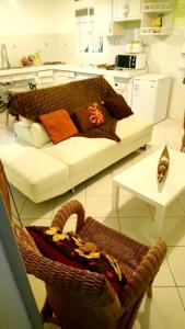 sala de estar con sofá y silla con almohadas en Maison de 2 chambres avec jardin clos et wifi a Saint Anne a 3 km de la plage, en Sainte-Anne