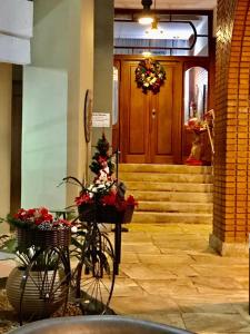 una bicicleta estacionada frente a una puerta con flores en cestas en Hotel Verdes Mares, en Ouro Branco