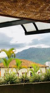 vistas a un edificio con palmeras y montañas en Hotel Verdes Mares, en Ouro Branco