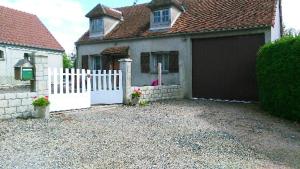 ein Haus mit einem weißen Zaun und einer Garage in der Unterkunft Maison d'une chambre avec wifi a Saint Pere in Saint-Père
