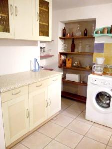 una cucina con armadietti bianchi e lavatrice di Appartement d'une chambre avec jardin clos et wifi a Hirel a Hirel
