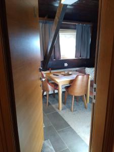 jadalnia ze stołem i krzesłami oraz oknem w obiekcie Megi apartman - Konaci Maglic w mieście Kopaonik