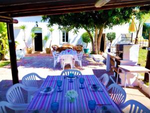 uma mesa roxa e cadeiras brancas e uma mesa e chairsearcher em 6 bedrooms villa with sea view and private pool at Loule em Loulé