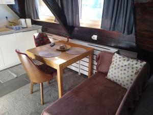 Pokój ze stołem, kanapą, stołem i krzesłem w obiekcie Megi apartman - Konaci Maglic w mieście Kopaonik