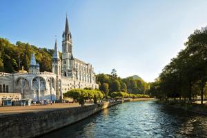 a building next to a river with a church at Appartement cosy à Tarbes - Terrasse et jardin clôturé in Tarbes