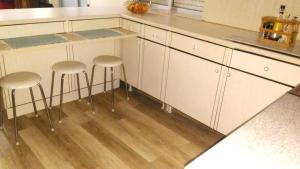 a kitchen with white cabinets and two stools at Charming house with mountain view in Manteigas, fireplace in Manteigas