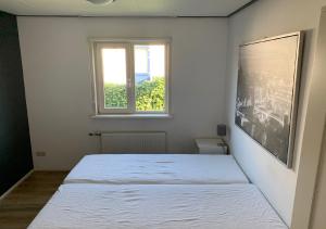 シント・アナラントにあるChaletparc Krabbenkreek Zeeland - Chalet 108の窓付きのベッドルーム1室(白いベッド1台付)