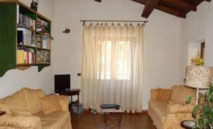 een woonkamer met een bank en een raam bij Agriturismo Spino Fiorito in Casola in Lunigiana